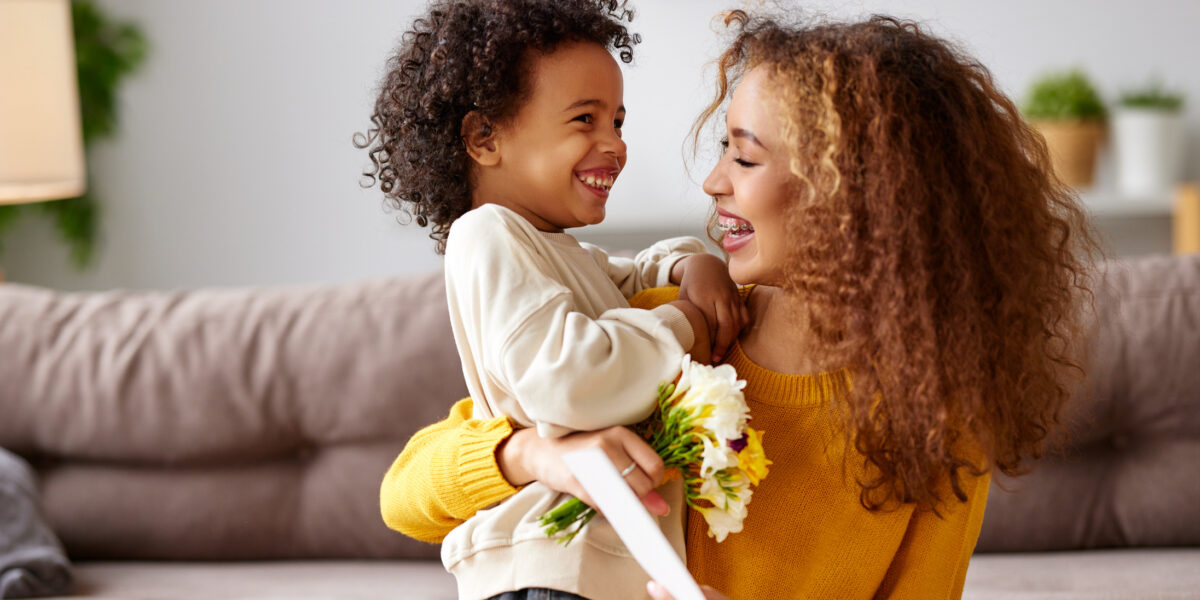 Young mixed race woman getting congratulations from son on Mothe